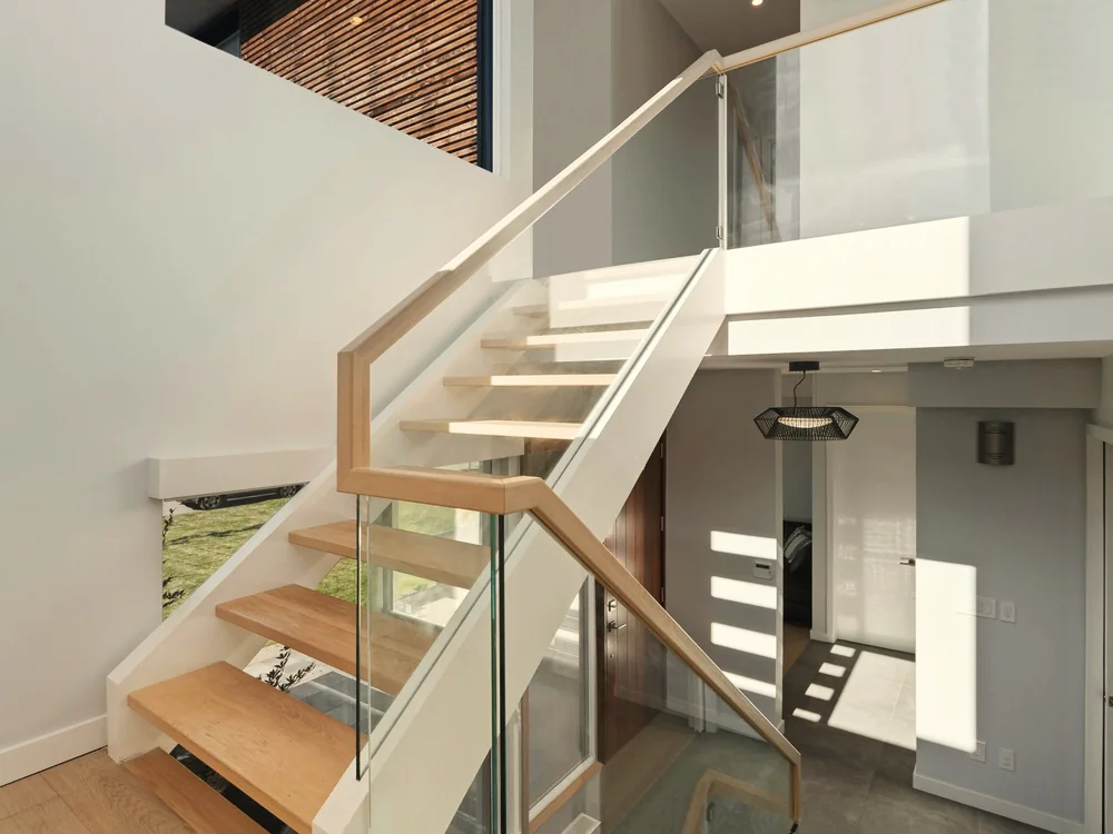 Open trap met houten treden en een glazen balustrade