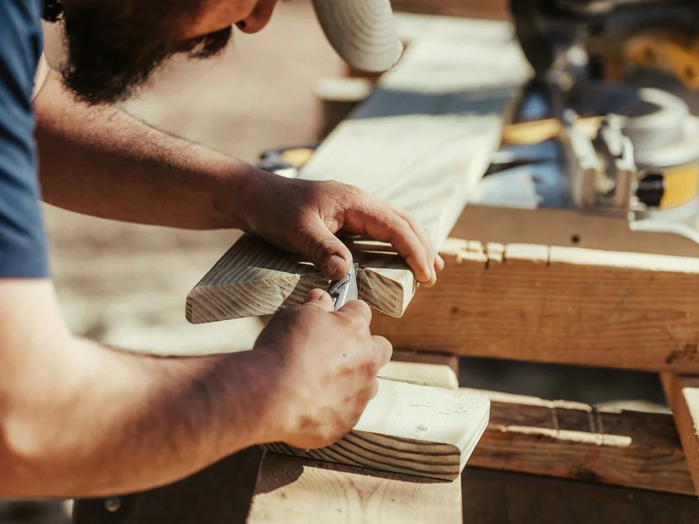 Vakman die houten delen op maat bewerkt