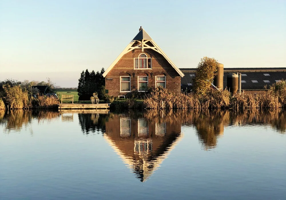 Boerderij met een rieten dak aan het water